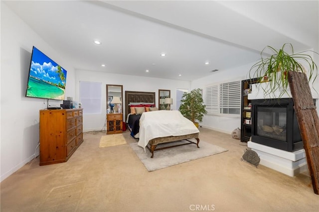 bedroom featuring light carpet, recessed lighting, visible vents, baseboards, and a multi sided fireplace