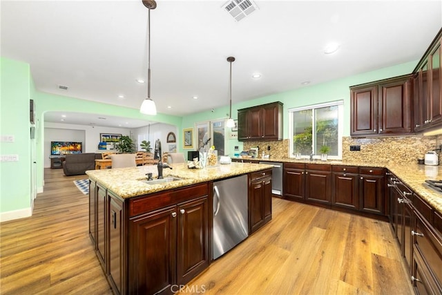 kitchen with open floor plan, decorative light fixtures, visible vents, and stainless steel dishwasher