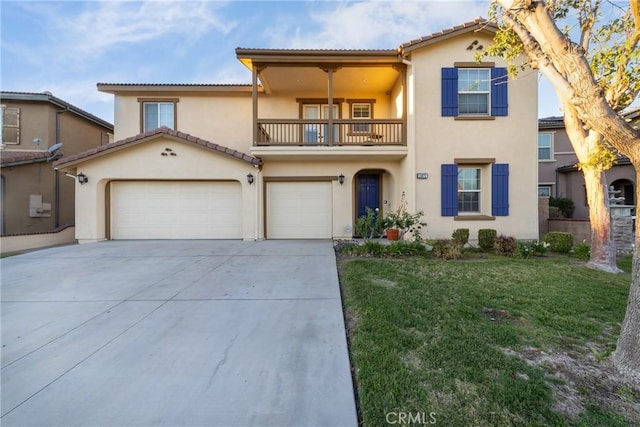 mediterranean / spanish home featuring a balcony, driveway, a front yard, and stucco siding