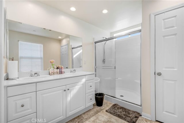 bathroom featuring vanity and a shower with shower door