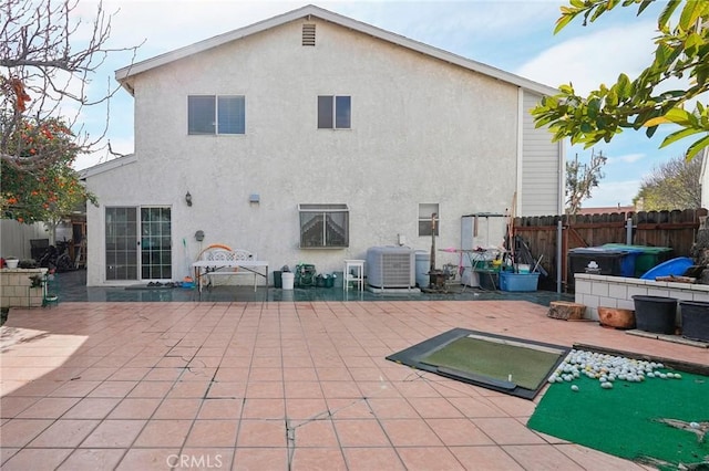 rear view of property featuring central AC unit and a patio area