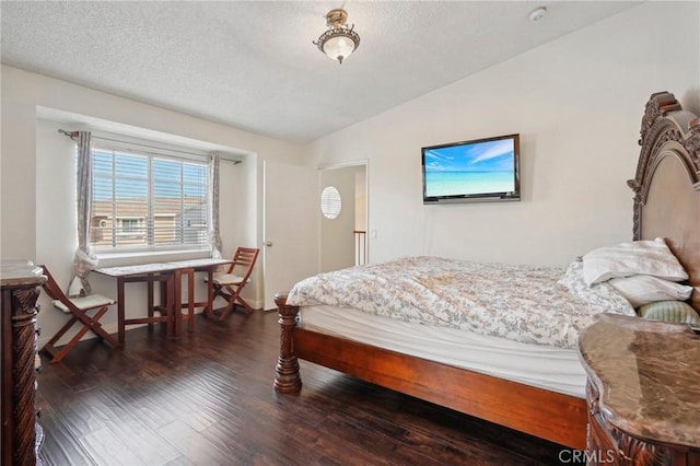 bedroom with lofted ceiling, dark wood-type flooring, and a textured ceiling