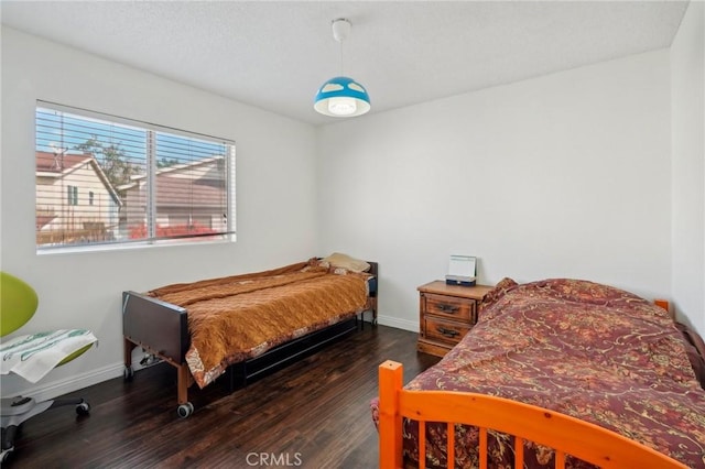 bedroom with dark wood-type flooring