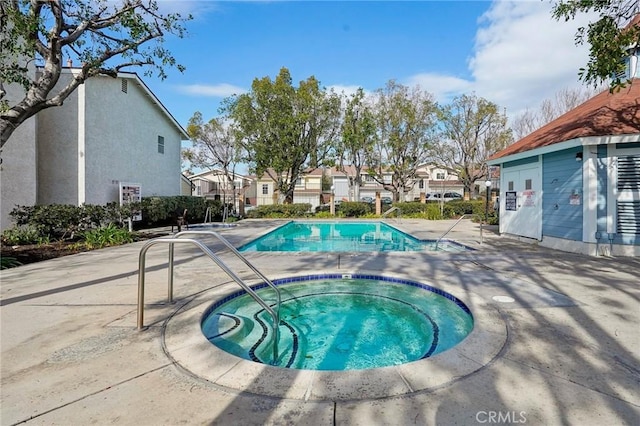 view of pool with a hot tub and a patio area