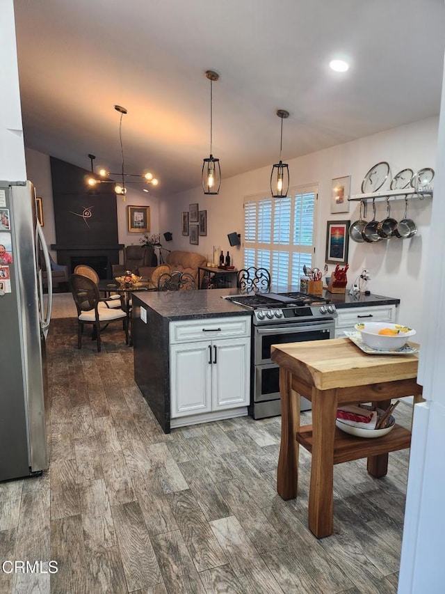 kitchen featuring white cabinetry, hanging light fixtures, dark hardwood / wood-style flooring, and appliances with stainless steel finishes