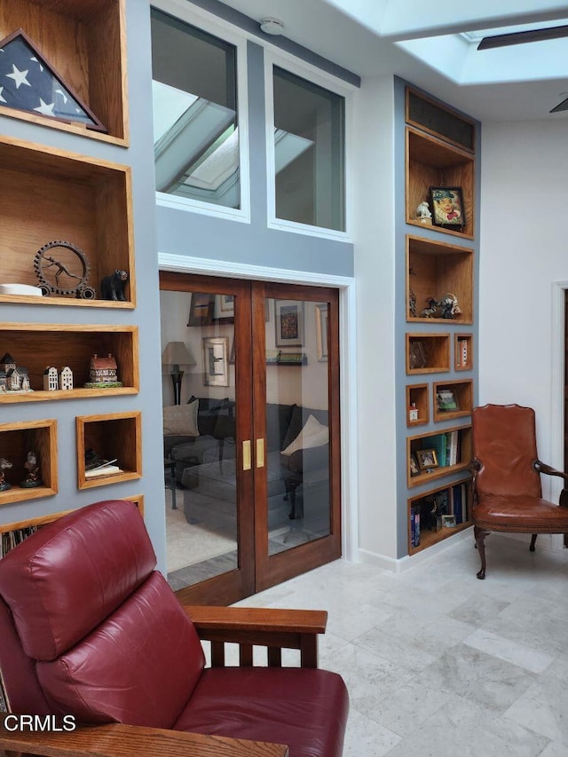 living area featuring french doors and built in shelves