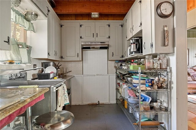 kitchen with white cabinetry, sink, and backsplash