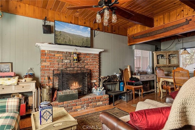 living room with wood walls, a brick fireplace, wooden ceiling, beamed ceiling, and hardwood / wood-style floors