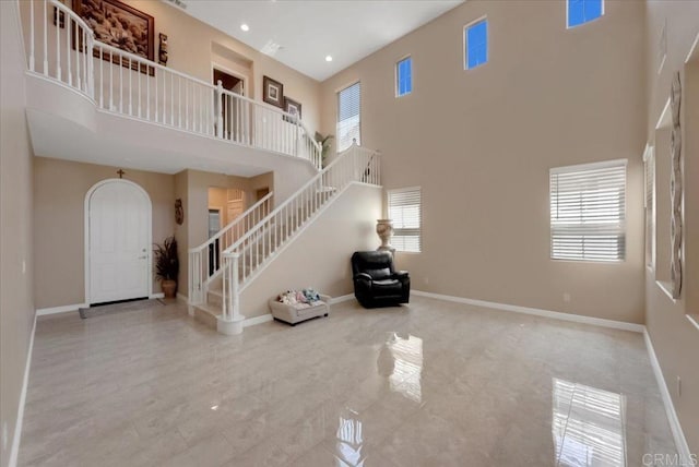 unfurnished living room featuring a towering ceiling