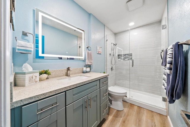 bathroom with vanity, hardwood / wood-style floors, toilet, and walk in shower