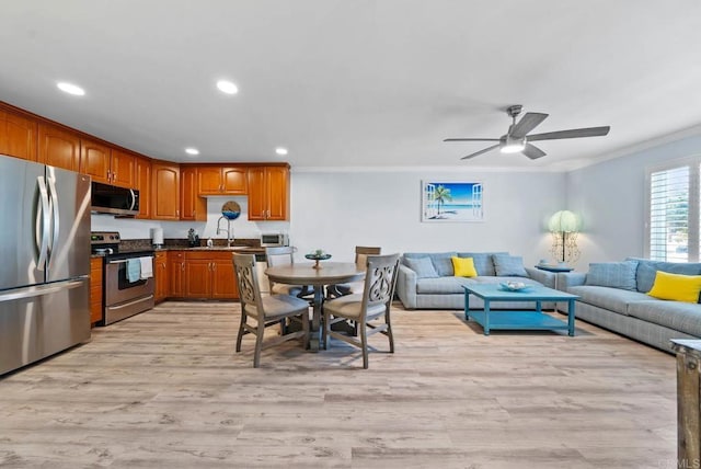 kitchen featuring sink, crown molding, light hardwood / wood-style flooring, appliances with stainless steel finishes, and ceiling fan