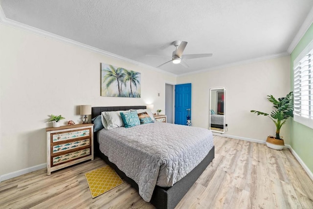 bedroom with ceiling fan, ornamental molding, light hardwood / wood-style flooring, and a textured ceiling