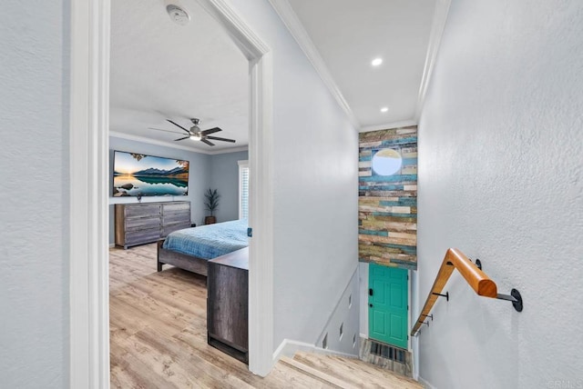 hallway with ornamental molding and light hardwood / wood-style flooring