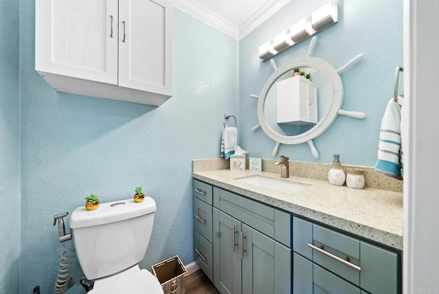 bathroom with crown molding, vanity, and toilet