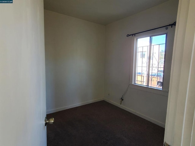 empty room featuring dark colored carpet