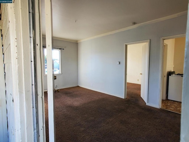 unfurnished room featuring ornamental molding and dark colored carpet