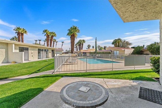 view of swimming pool featuring a lawn and a patio