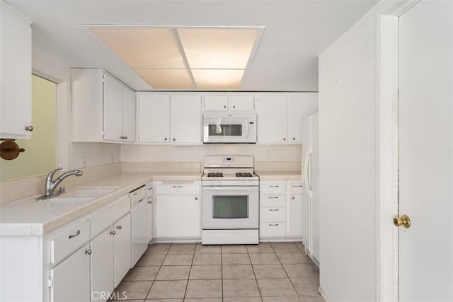 kitchen featuring white cabinetry, white appliances, light tile patterned flooring, and sink