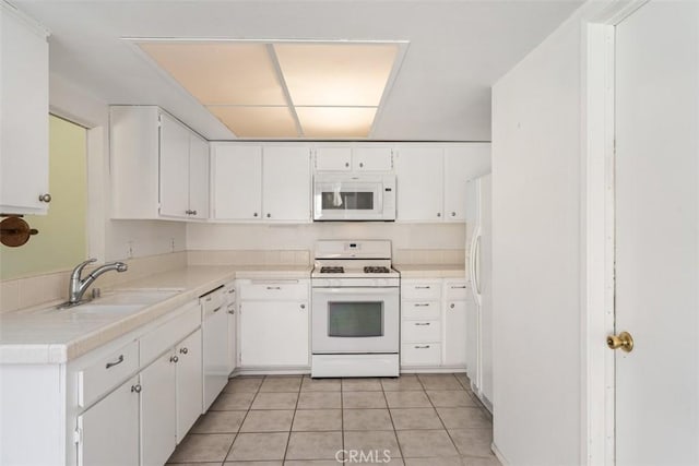 kitchen featuring light countertops, white appliances, light tile patterned flooring, and white cabinets