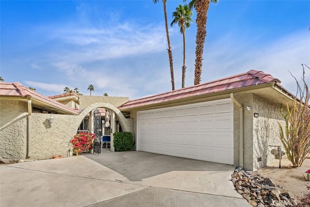 view of front facade featuring a garage, a tile roof, driveway, and stucco siding