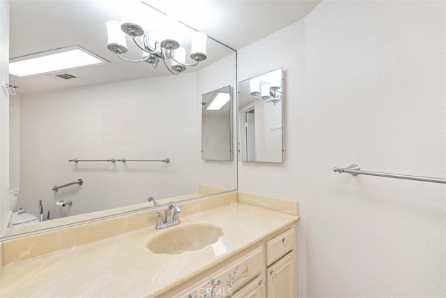 bathroom featuring visible vents, toilet, and vanity