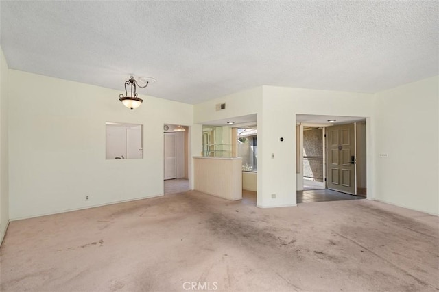 spare room with carpet flooring and a textured ceiling