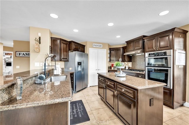 kitchen featuring light stone countertops, appliances with stainless steel finishes, and kitchen peninsula