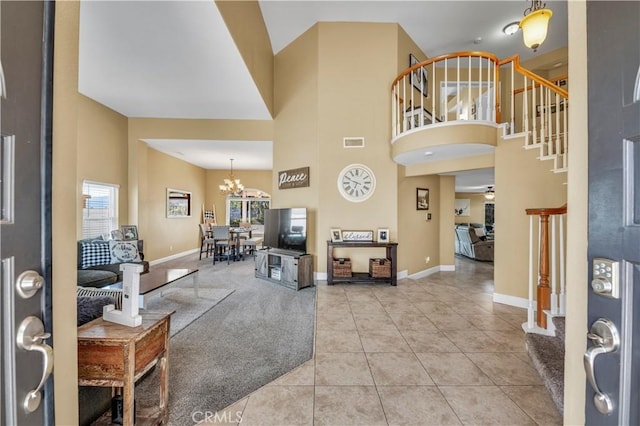 entryway featuring a high ceiling, light tile patterned flooring, and a chandelier