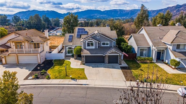 view of front of property with a mountain view, a front lawn, and solar panels