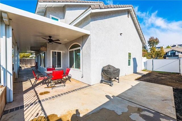 rear view of house featuring ceiling fan and a patio