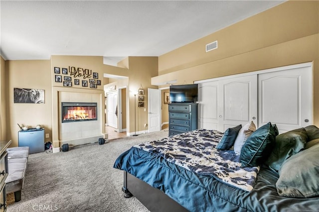 bedroom featuring light carpet, lofted ceiling, and a closet