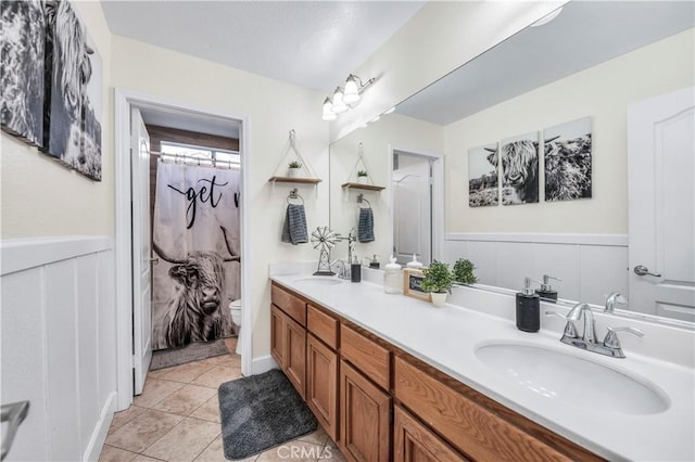 bathroom with tile patterned flooring, vanity, and toilet