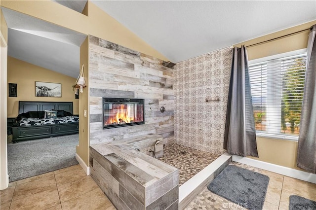 bathroom featuring tile patterned floors, lofted ceiling, and a tile fireplace