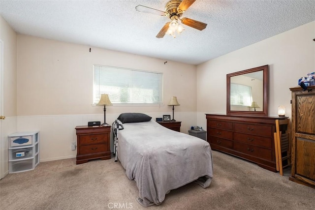 carpeted bedroom with a textured ceiling and ceiling fan