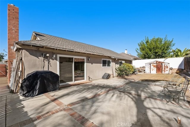 back of house featuring a storage unit and a patio