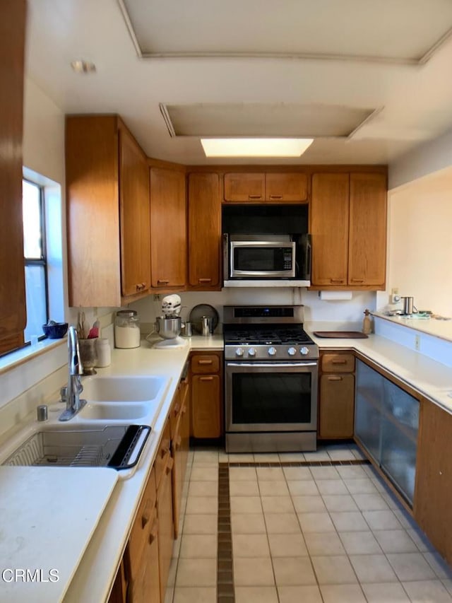 kitchen with sink, light tile patterned flooring, and appliances with stainless steel finishes