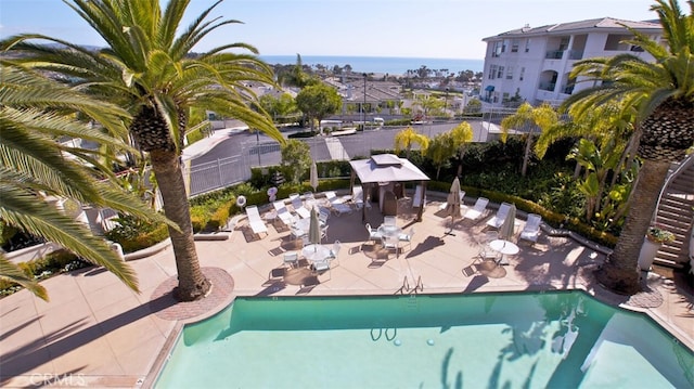 view of swimming pool with a water view, a gazebo, and a patio area