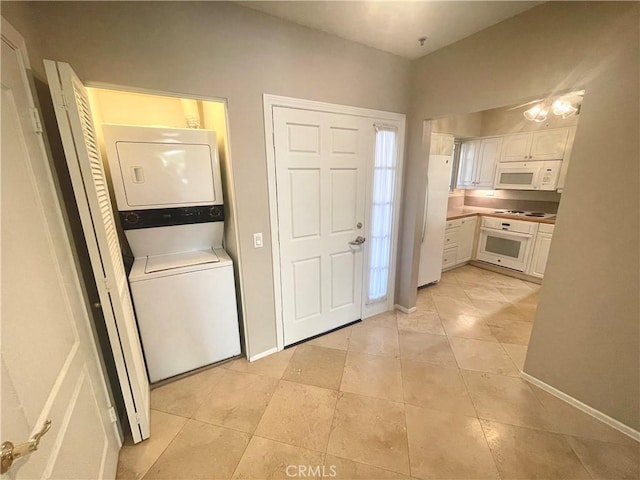 laundry area featuring light tile patterned flooring and stacked washer and clothes dryer