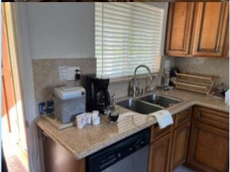 kitchen with sink, stainless steel dishwasher, and backsplash