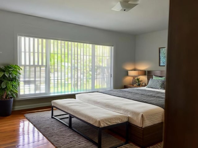 bedroom with multiple windows and hardwood / wood-style flooring