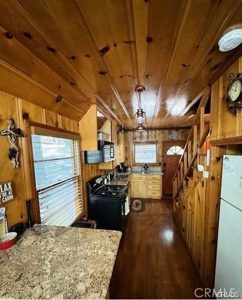 kitchen with wooden walls, black appliances, hardwood / wood-style flooring, kitchen peninsula, and wooden ceiling