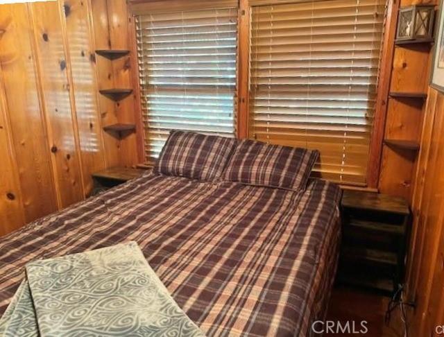 bedroom with wooden walls and a closet