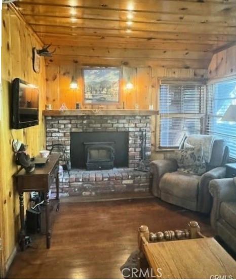 living room with wood walls, dark hardwood / wood-style flooring, vaulted ceiling, and wooden ceiling