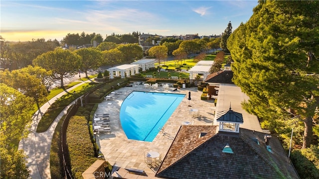 pool at dusk featuring a gazebo and a patio area