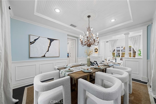 dining area featuring dark wood-type flooring, ornamental molding, and a raised ceiling