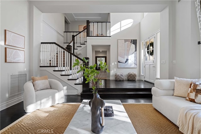 living room featuring a high ceiling and dark hardwood / wood-style flooring