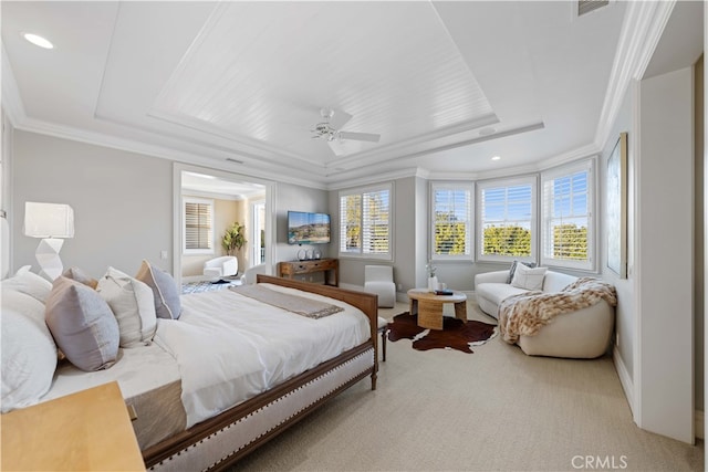 carpeted bedroom with ornamental molding, ceiling fan, and a tray ceiling