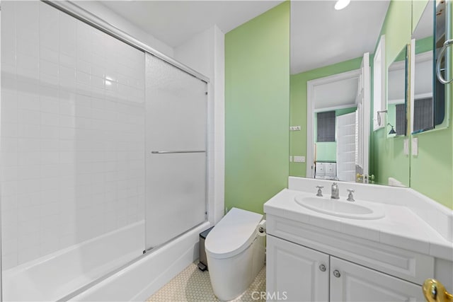 full bathroom featuring vanity, shower / bath combination with glass door, and toilet