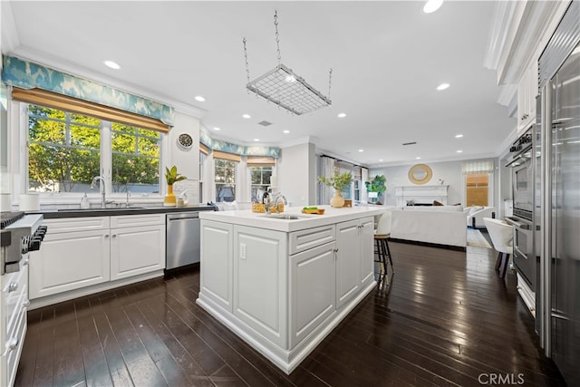 kitchen featuring dishwasher, white cabinetry, sink, a center island, and crown molding