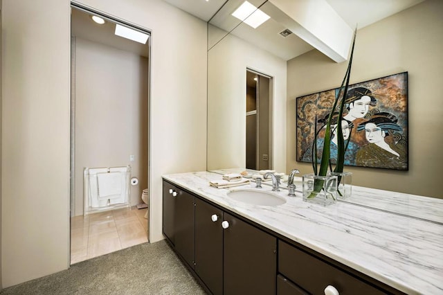 bathroom featuring tile patterned floors, vanity, and toilet